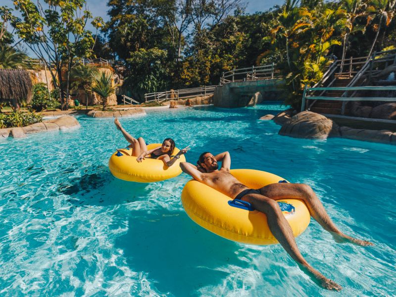 Casal flutuando em boias amarelas pela praia do Cerrado, no Hot Park